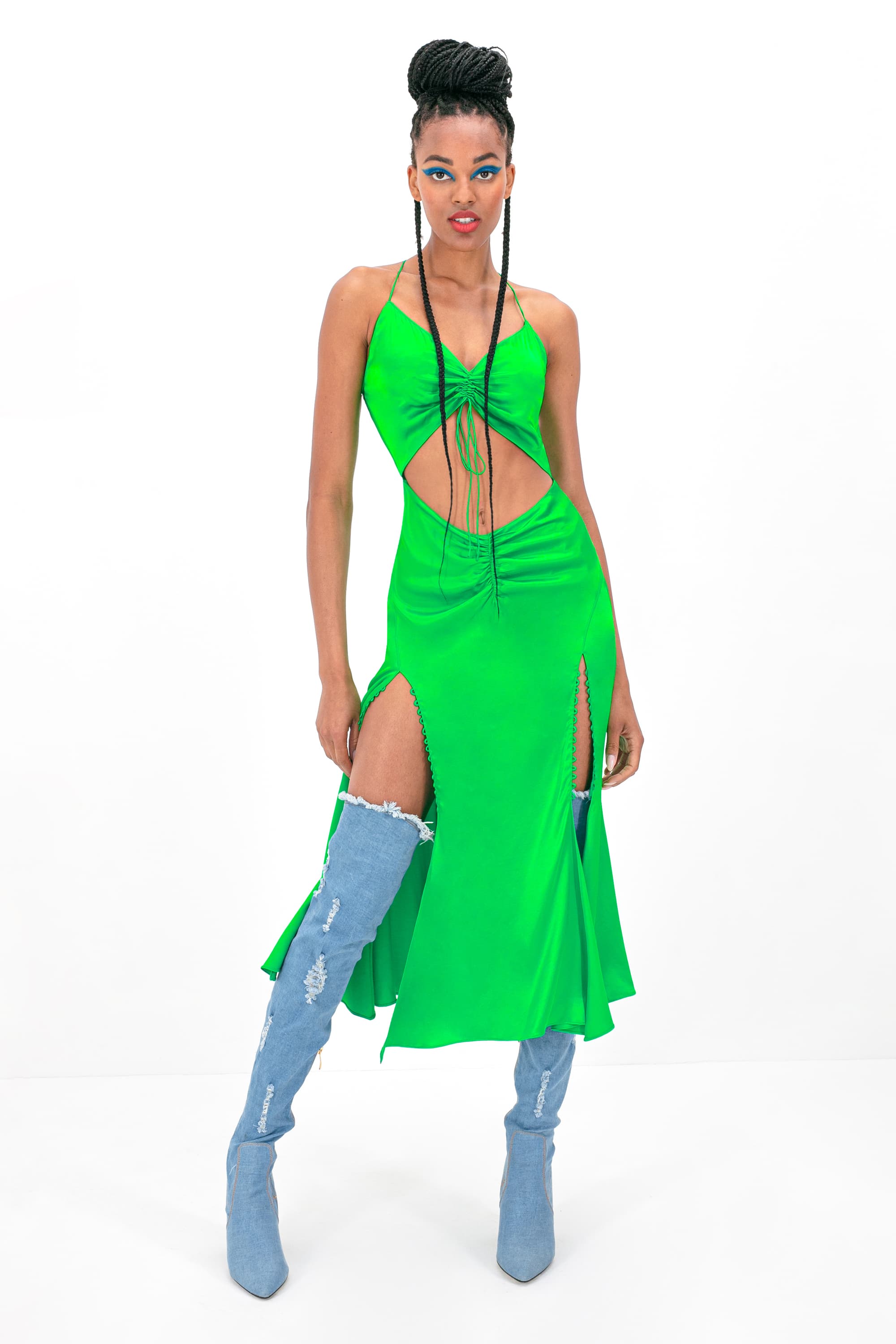 Woman wearing green Andromeda dress standing against white background, front view, full length shot, full body