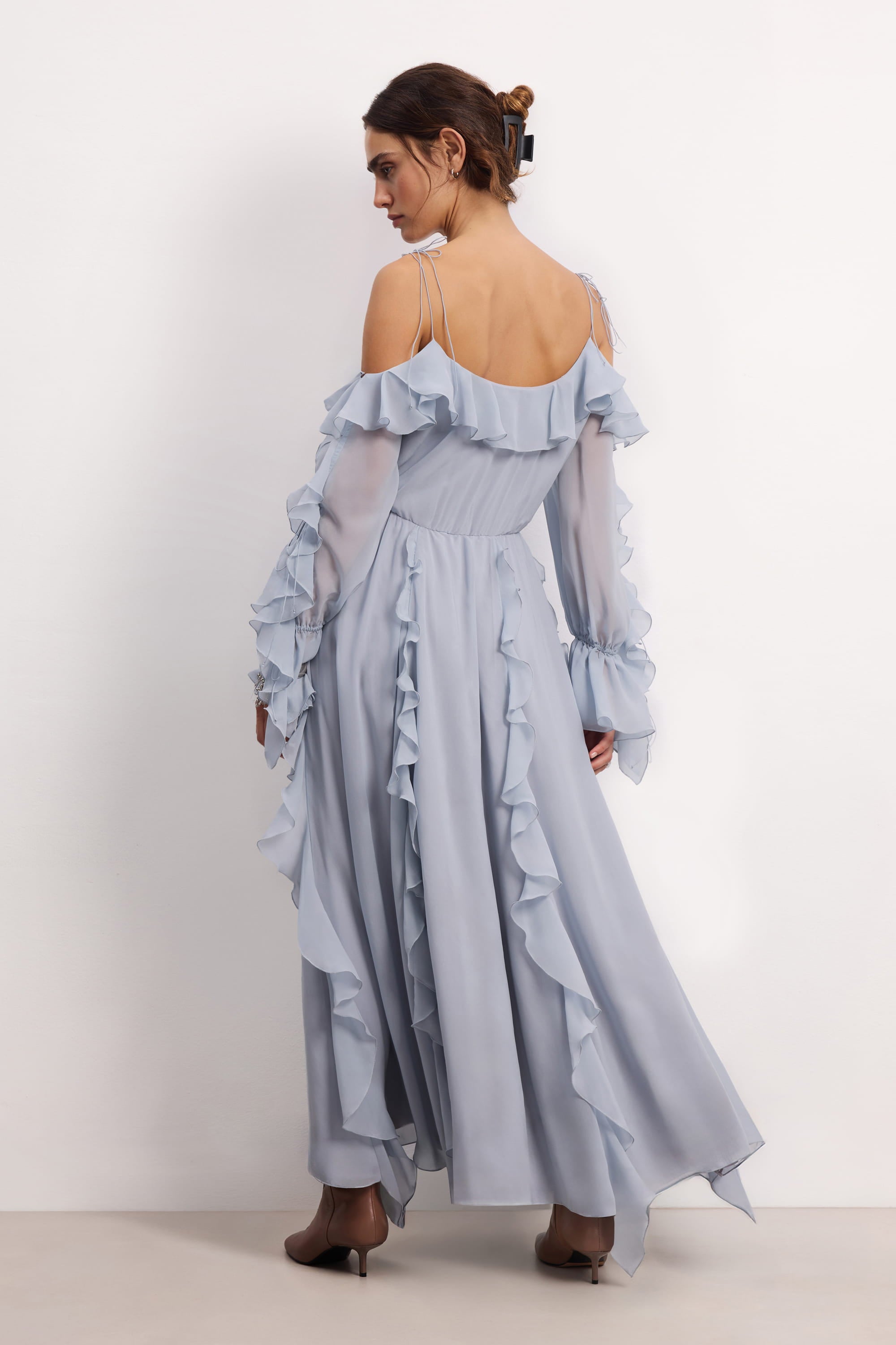 Woman wearing a blue fog off-shoulder ruffled Morning Forest midi dress on a white background, back view