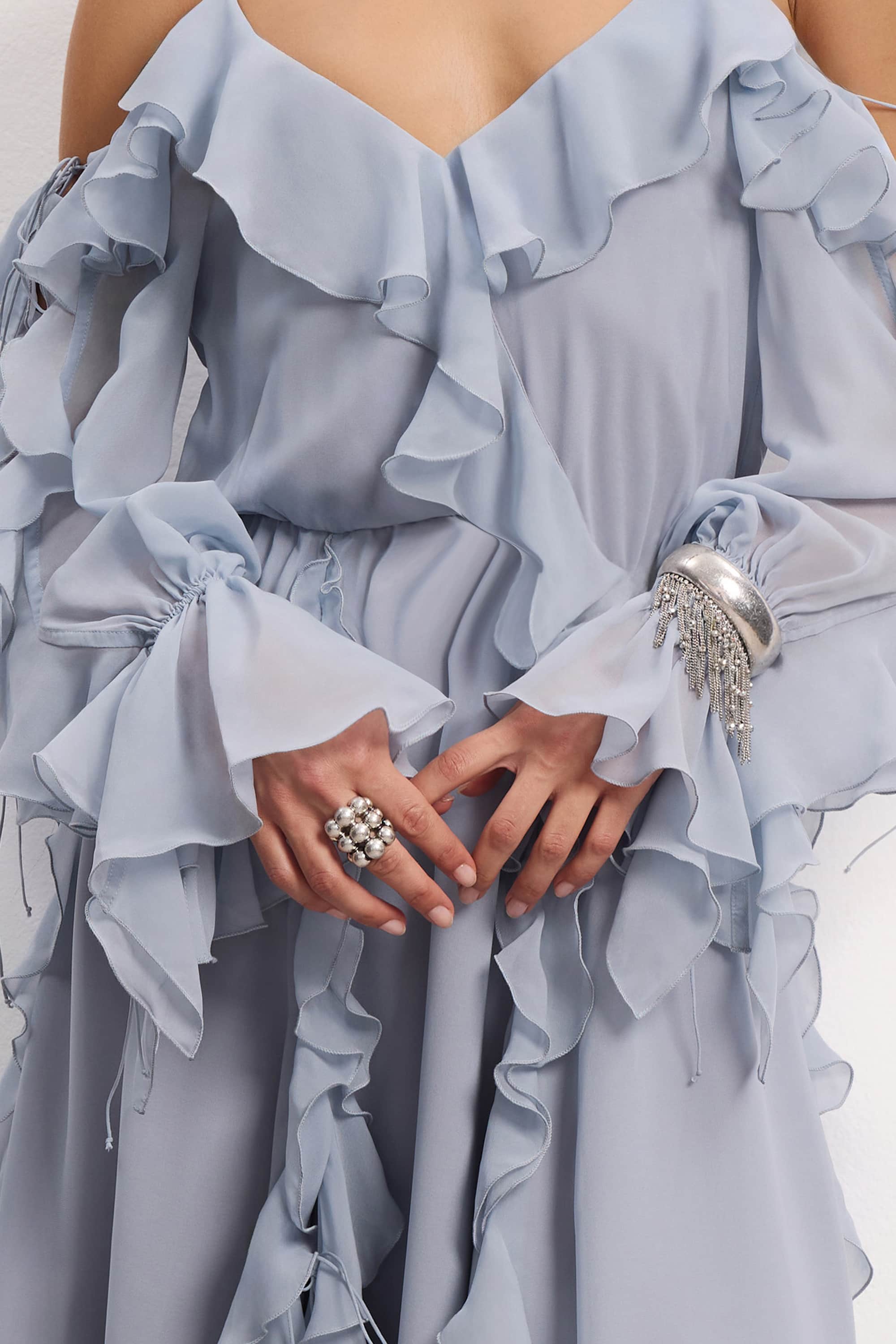 Woman wearing a blue fog off-shoulder ruffled Morning Forest midi dress on a white background, details front view