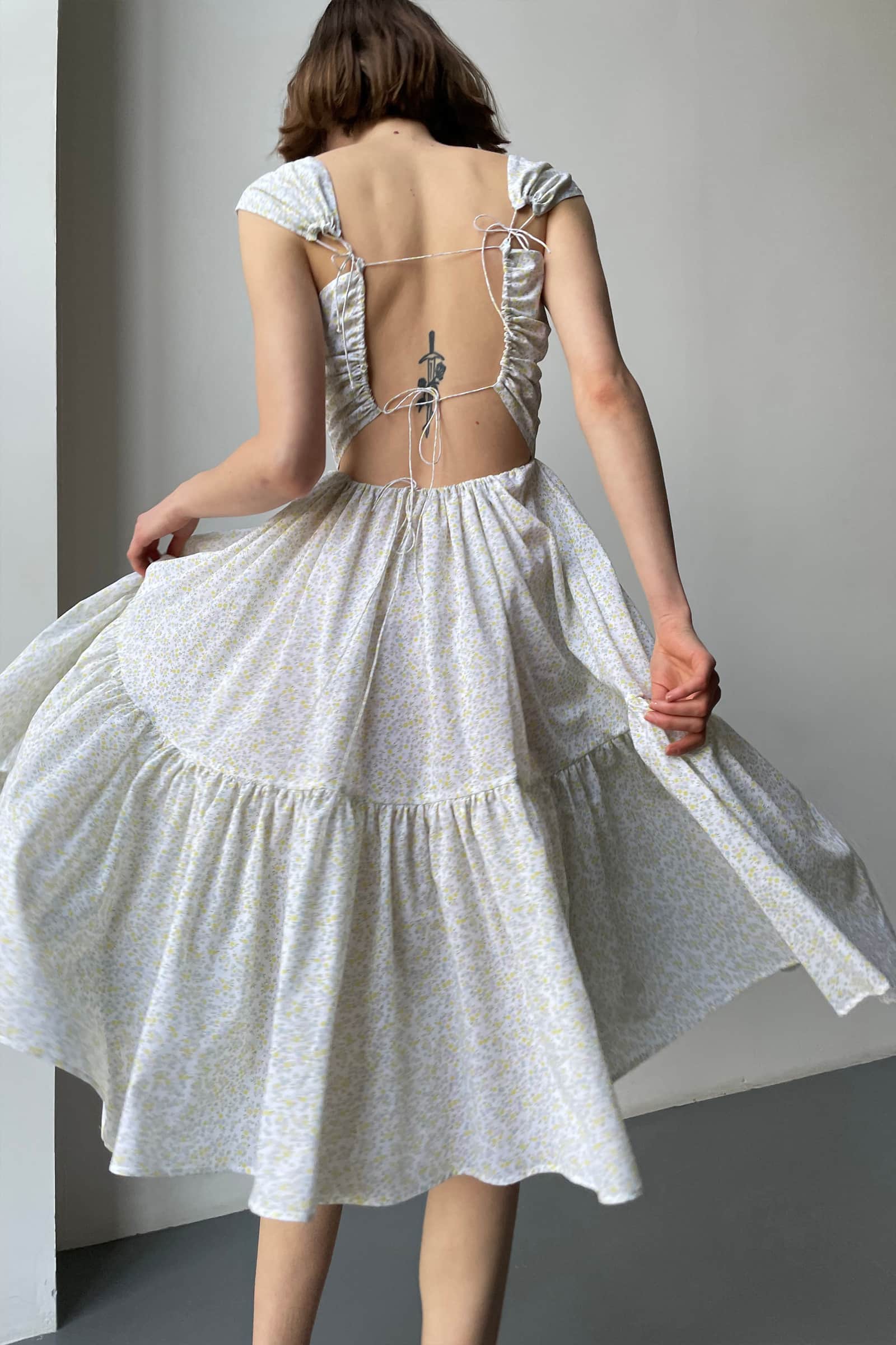 Model in open tie back Song of the Winds midi dress back view