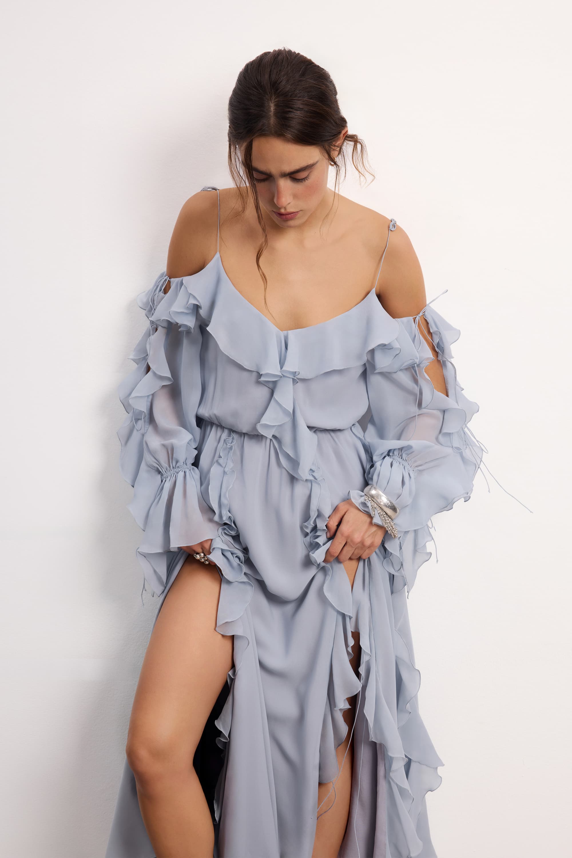 Woman wearing a blue fog off-shoulder ruffled Morning Forest midi dress on a white background, front view