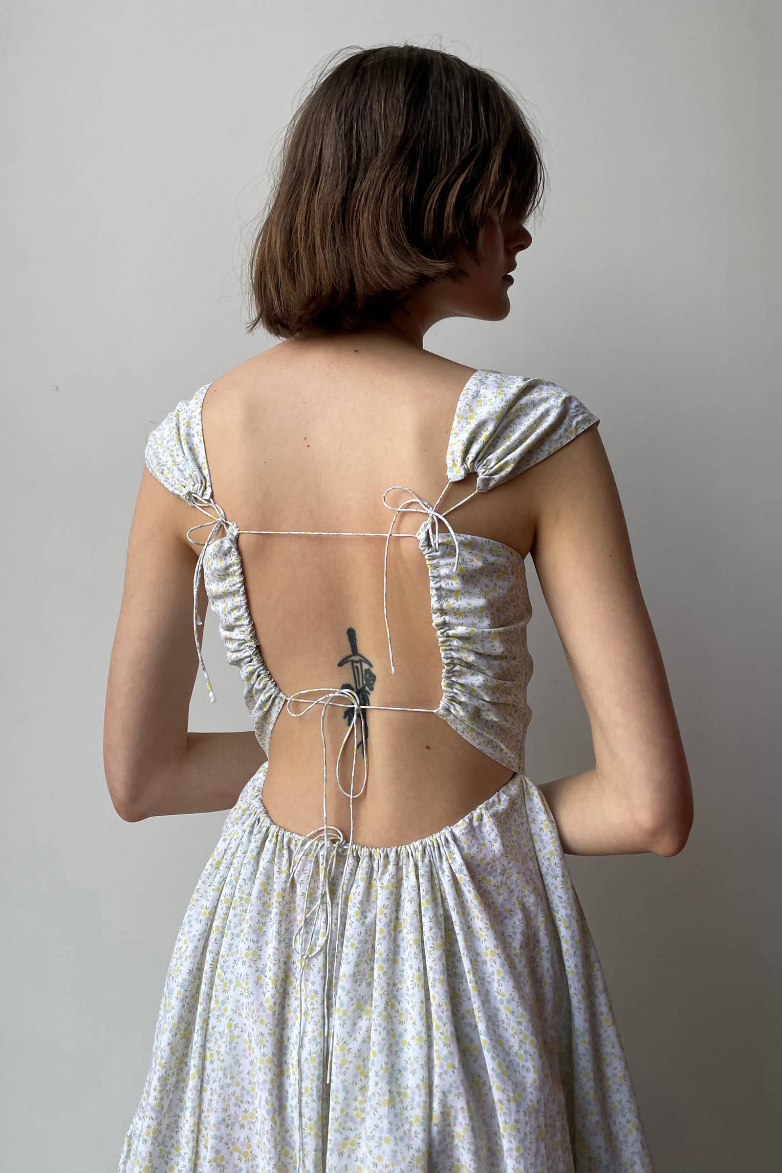 Model in open tie back Song of the Winds midi dress back view