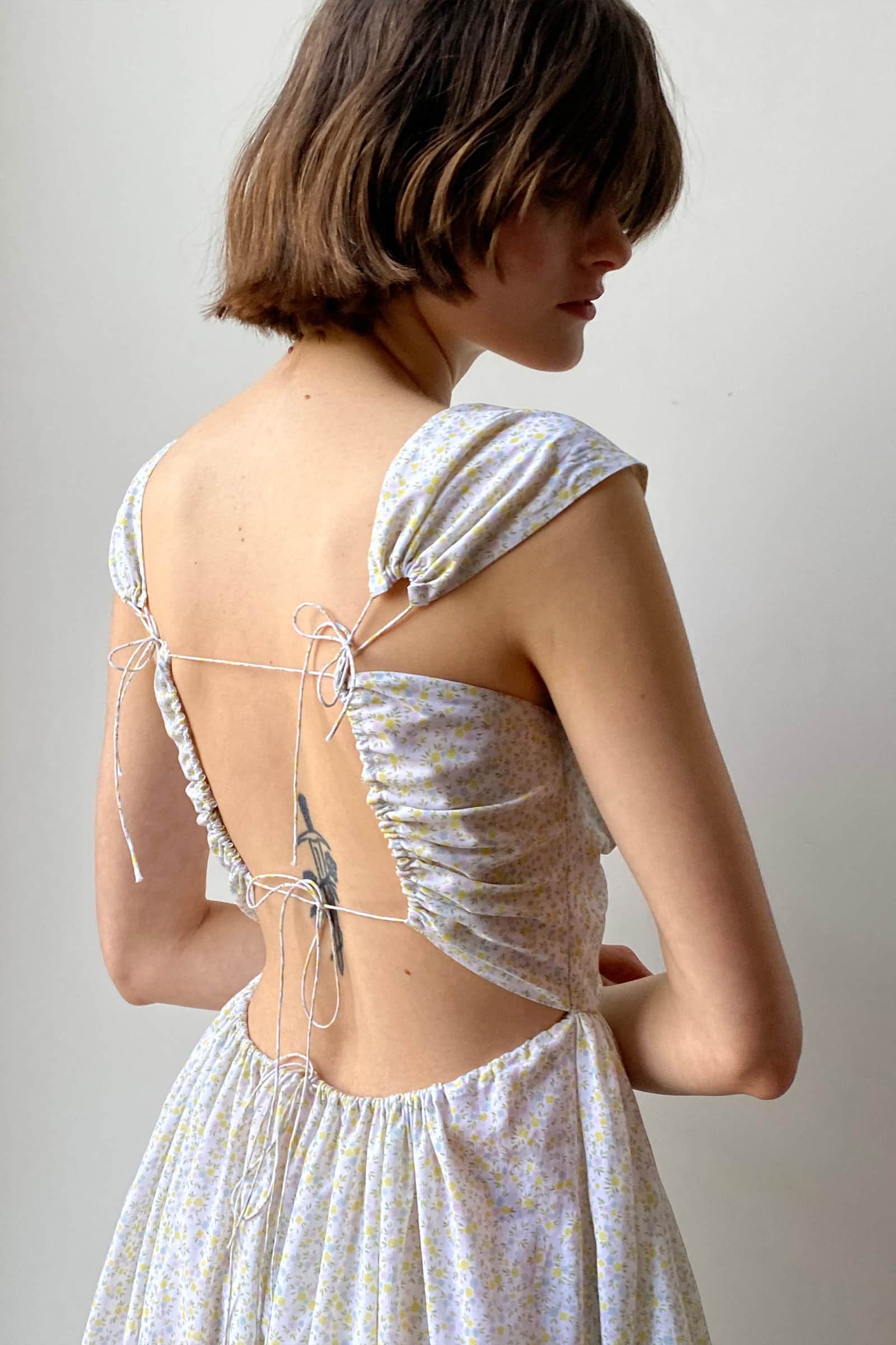Model in open tie back Song of the Winds midi dress side view