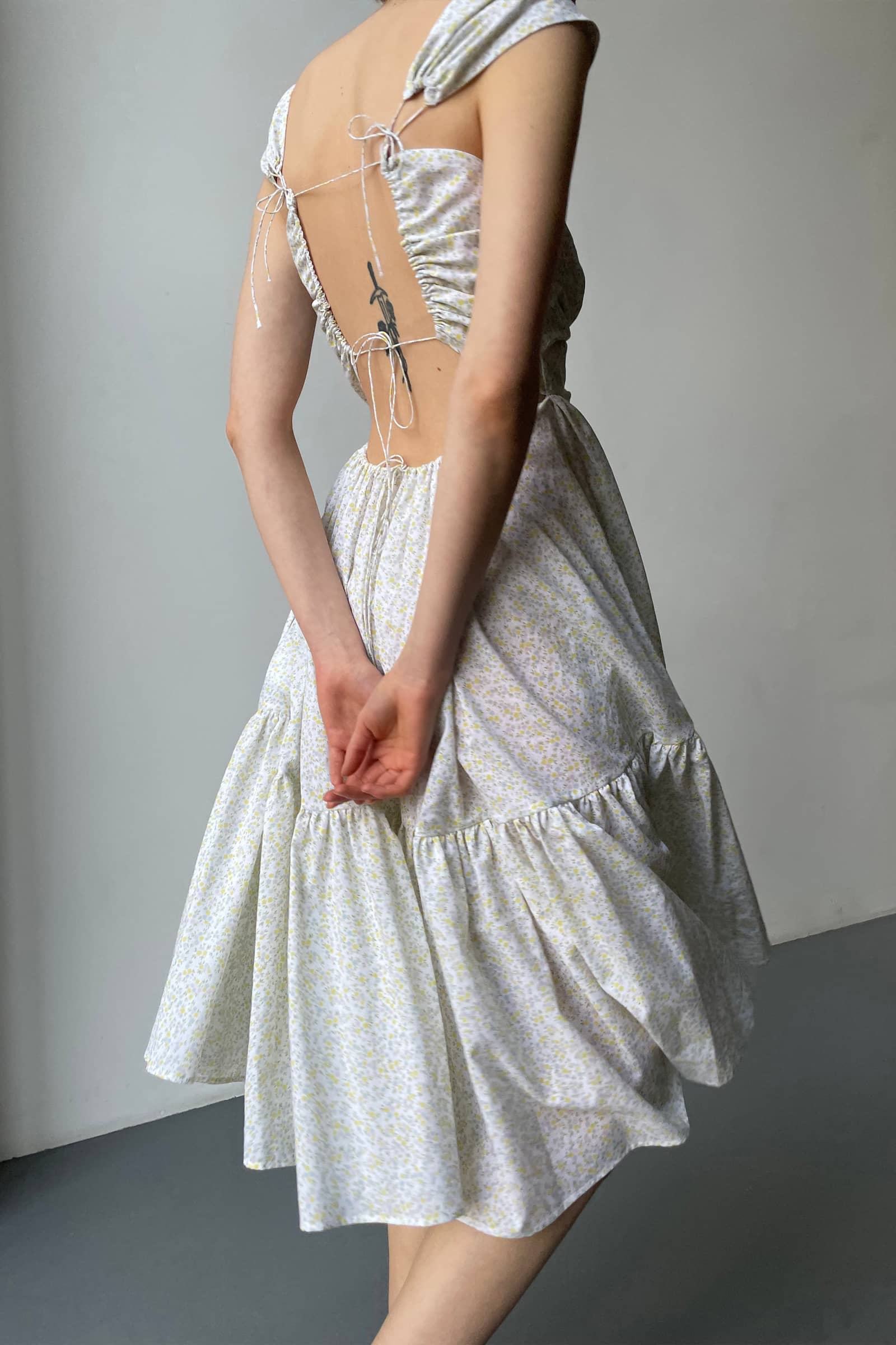 Model in open tie back Song of the Winds midi dress side view
